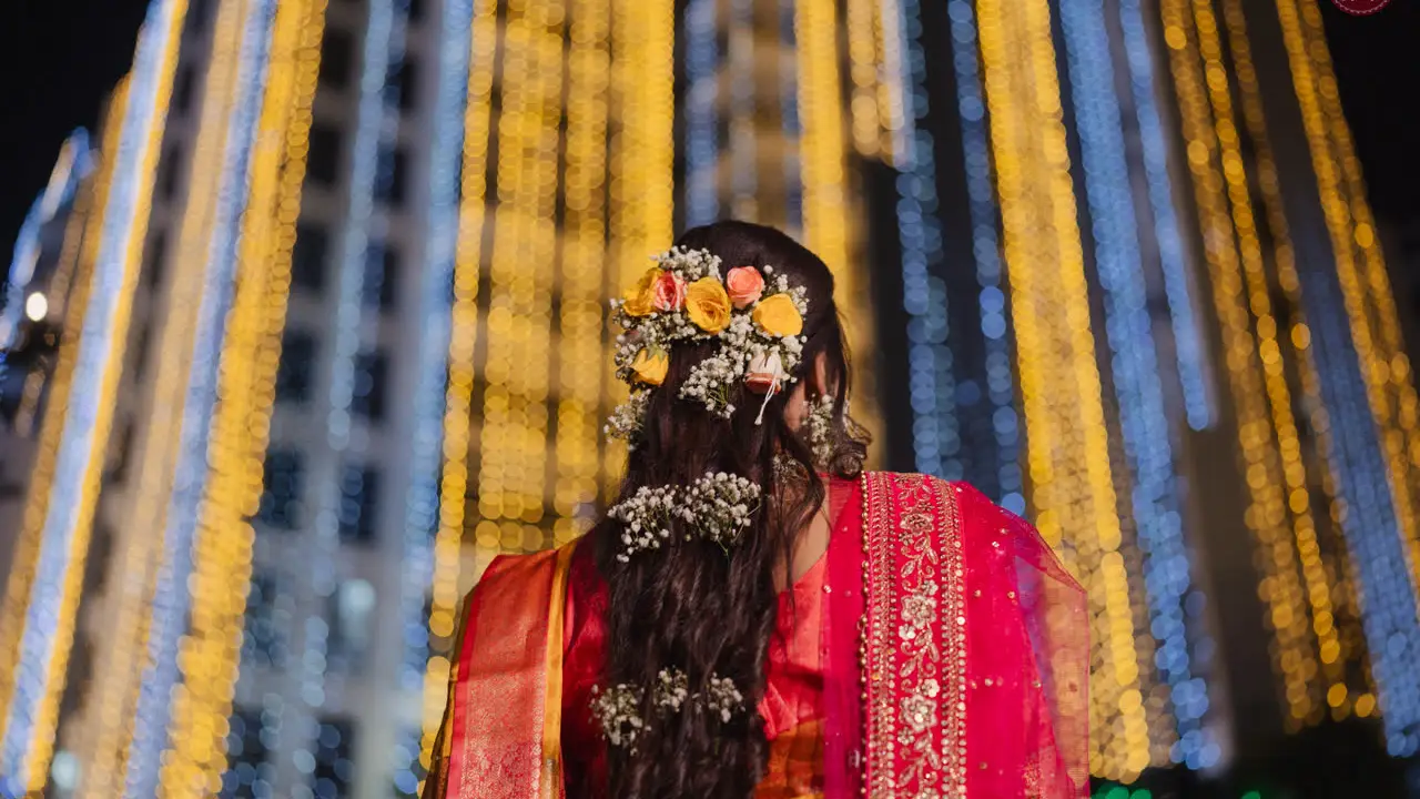 Film still: flowers in a braid against festival lights