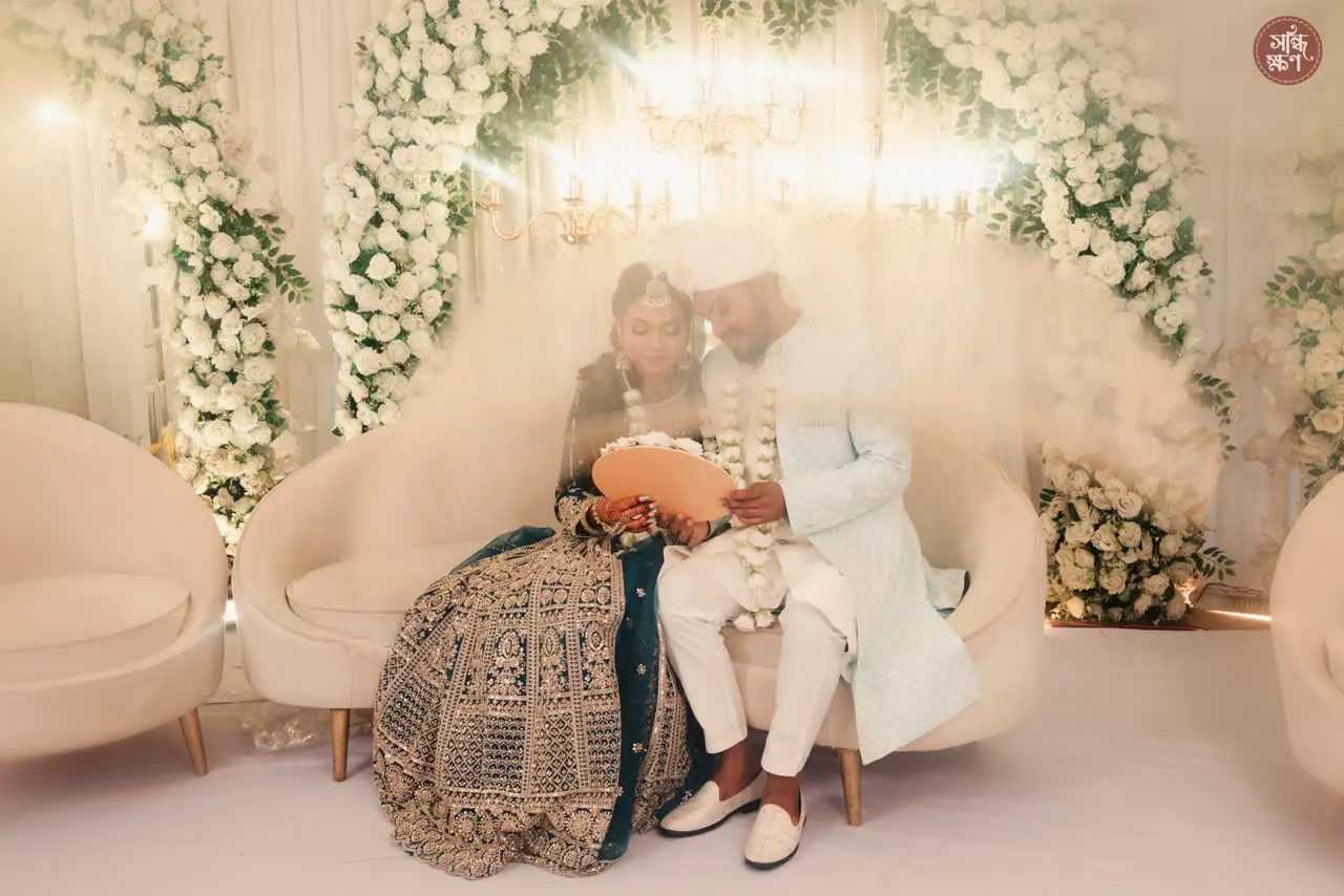 Nadia and Tanvir on a white floral stage
