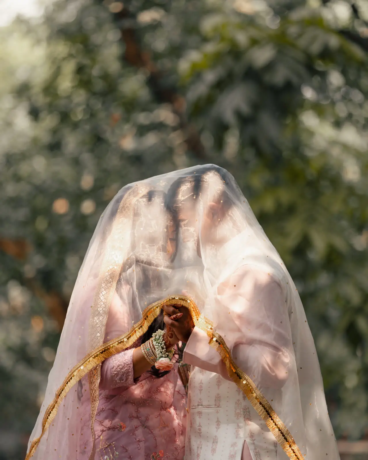 A sheer veil lifted over Nadia’s head, hands pressed together