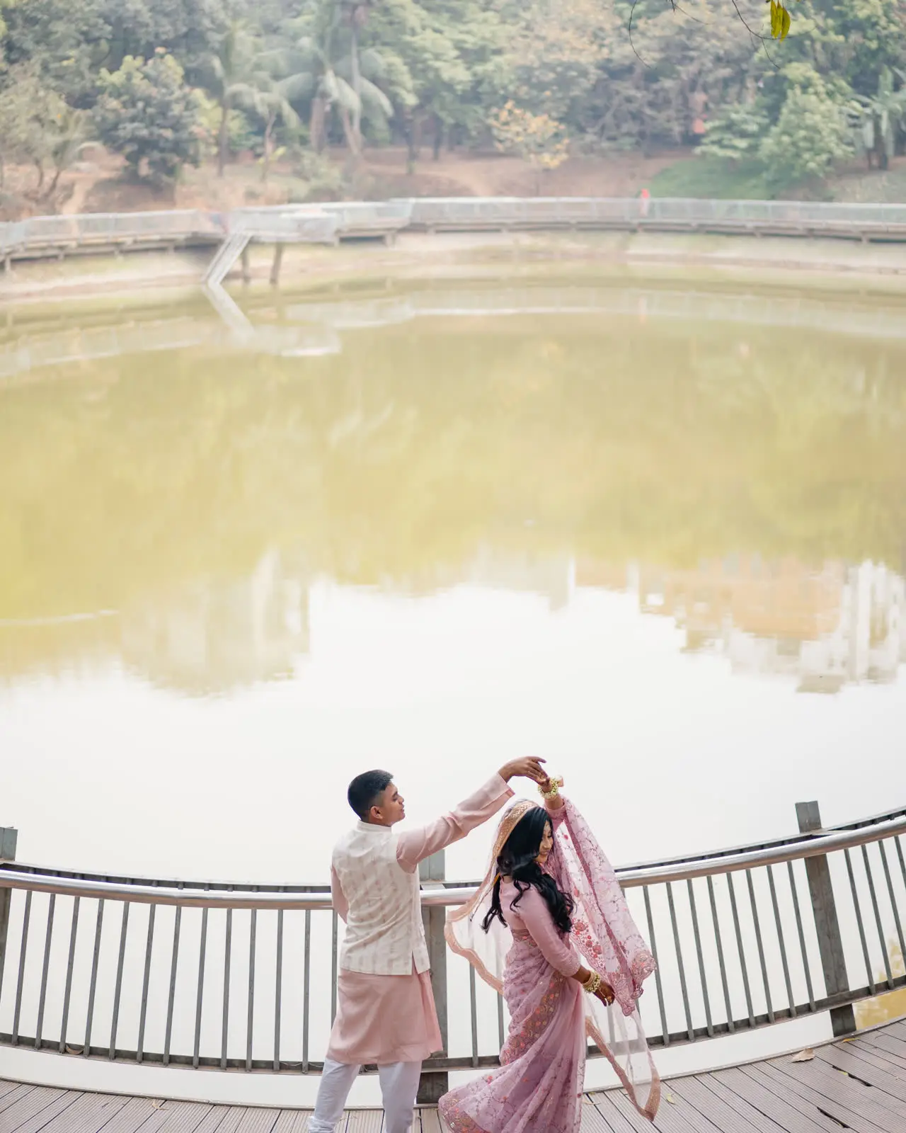 Tanvir twirls Nadia on a wooden deck by a lake